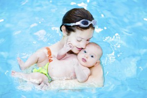 Mother and with cute little baby relaxing in swimming pool